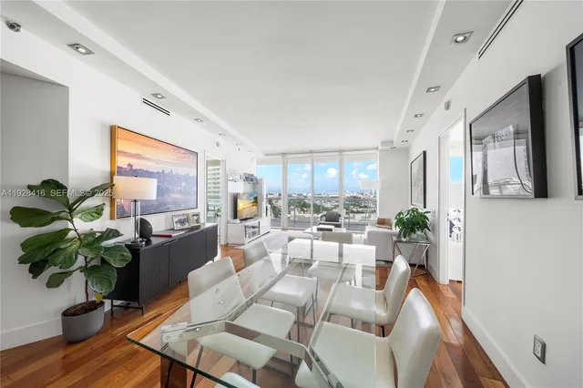 a living room with furniture potted plant and a wooden floor