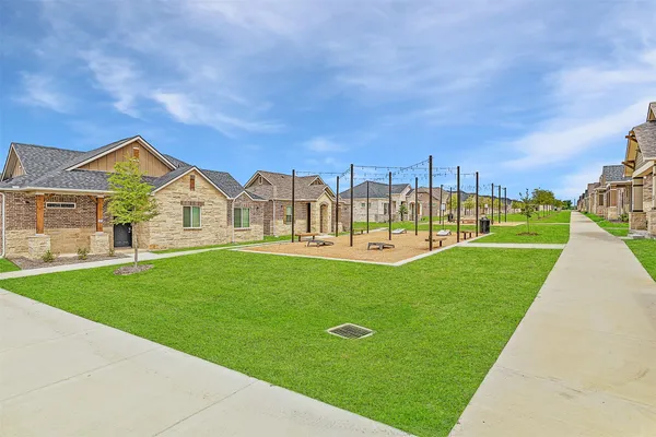 a view of a house with a big yard and large tree
