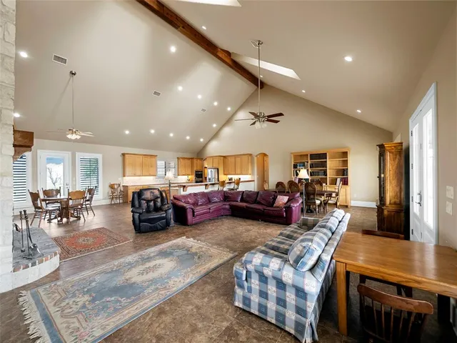 a living room with furniture a table and kitchen view