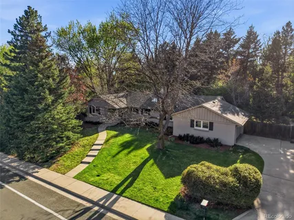 a view of a house with a yard and large trees