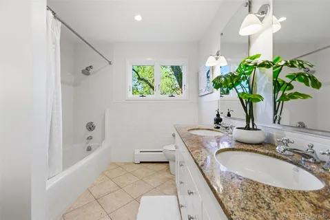 a bathroom with a granite countertop sink a toilet and a bathtub