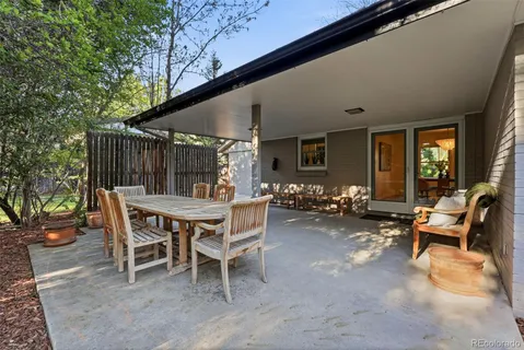 a view of a patio with a table chairs and a backyard