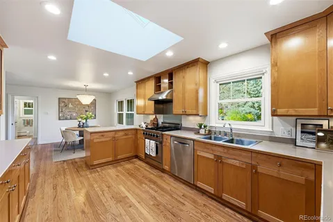 a kitchen with stainless steel appliances granite countertop sink stove top oven and cabinets