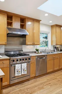 a kitchen with a stove and wooden cabinets