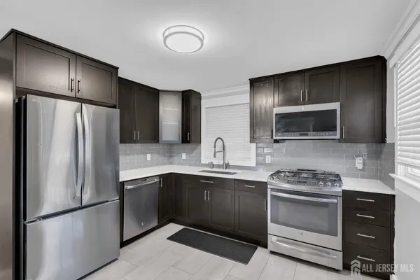 a kitchen with stainless steel appliances a refrigerator sink and stove