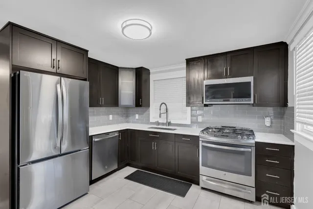 a kitchen with stainless steel appliances a refrigerator sink and stove