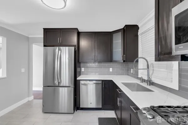 a kitchen with a sink a refrigerator and a stove top oven