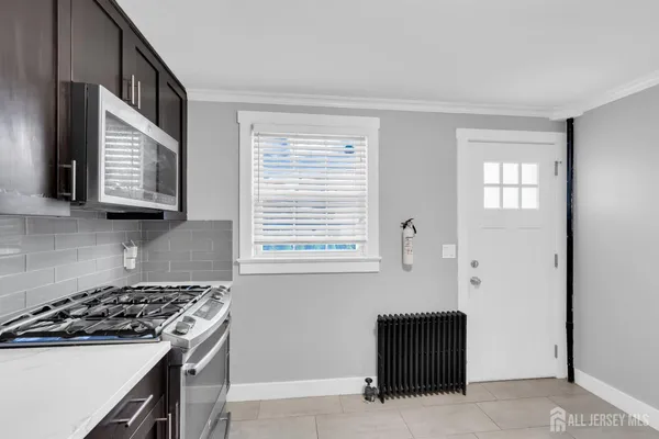 a kitchen with stainless steel appliances a stove a microwave and a window