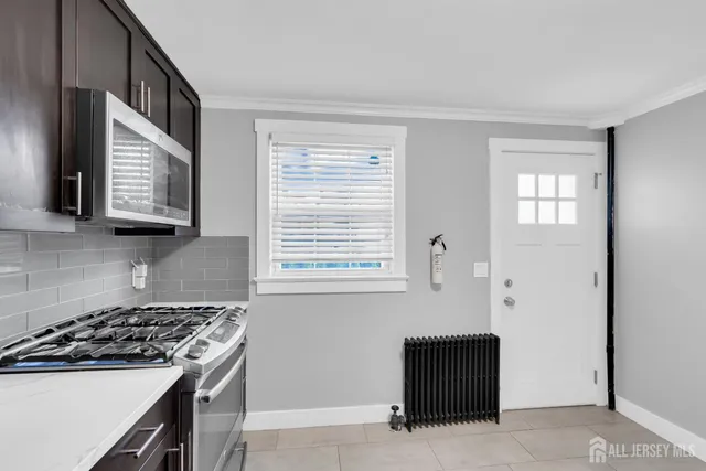 a kitchen with stainless steel appliances a stove a microwave and a window