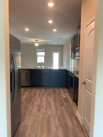 a large kitchen with a refrigerator and a sink