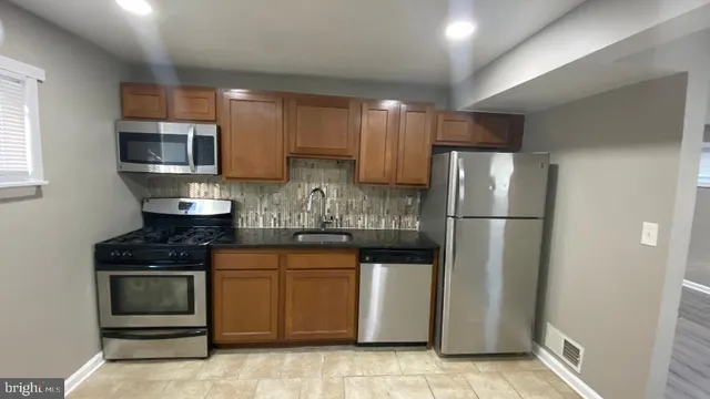a kitchen with stainless steel appliances granite countertop a refrigerator stove a sink and dishwasher