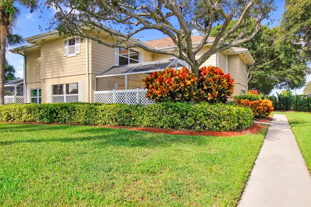 a front view of a house with a yard and potted plants