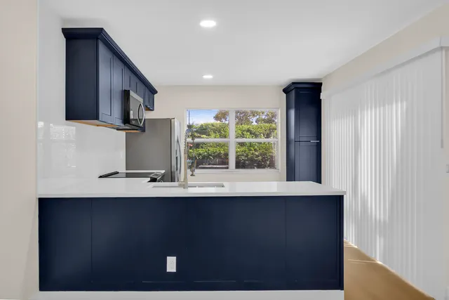a kitchen with a sink a window and a wooden floor