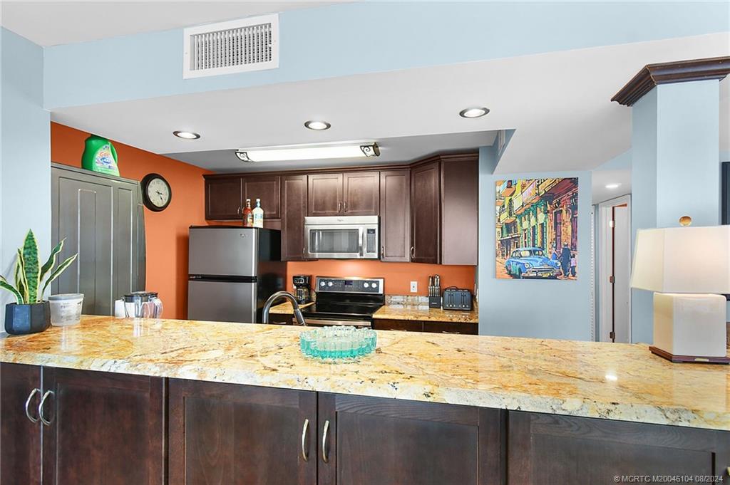 311 Golfview Circle Stuart, FL 34996 - Photo 13 of 37 a kitchen with stainless steel appliances granite countertop a sink refrigerator and microwave