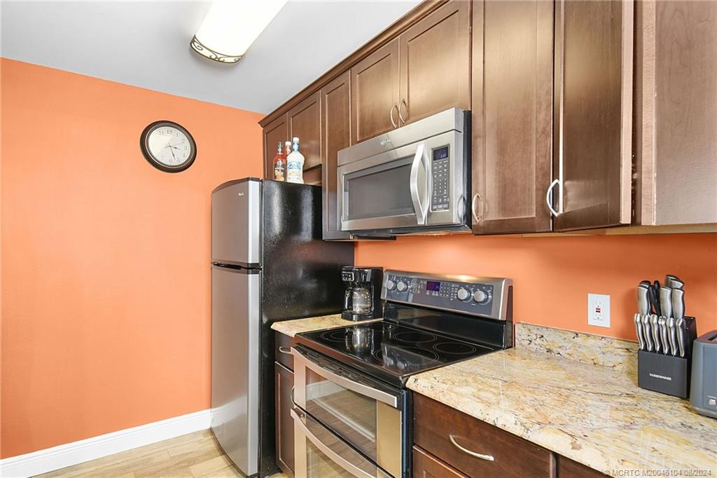 311 Golfview Circle Stuart, FL 34996 - Photo 15 of 37 a kitchen with granite countertop a sink a stove and microwave