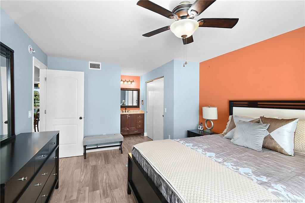 311 Golfview Circle Stuart, FL 34996 - Photo 19 of 37 a bedroom with a large bed and a chandelier