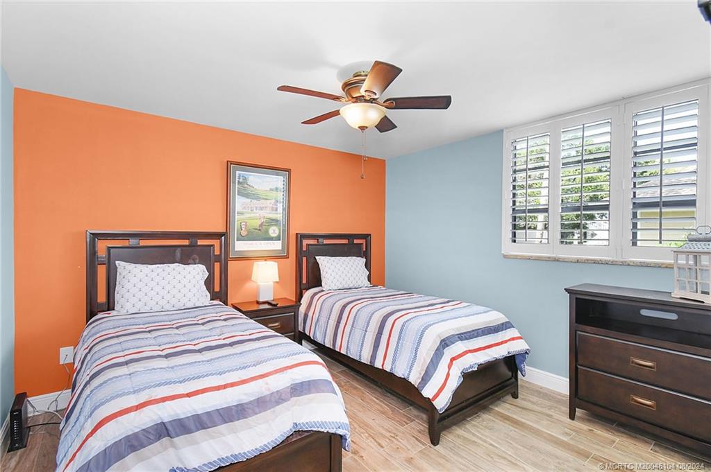 311 Golfview Circle Stuart, FL 34996 - Photo 22 of 37 a bedroom with two beds and a chandelier