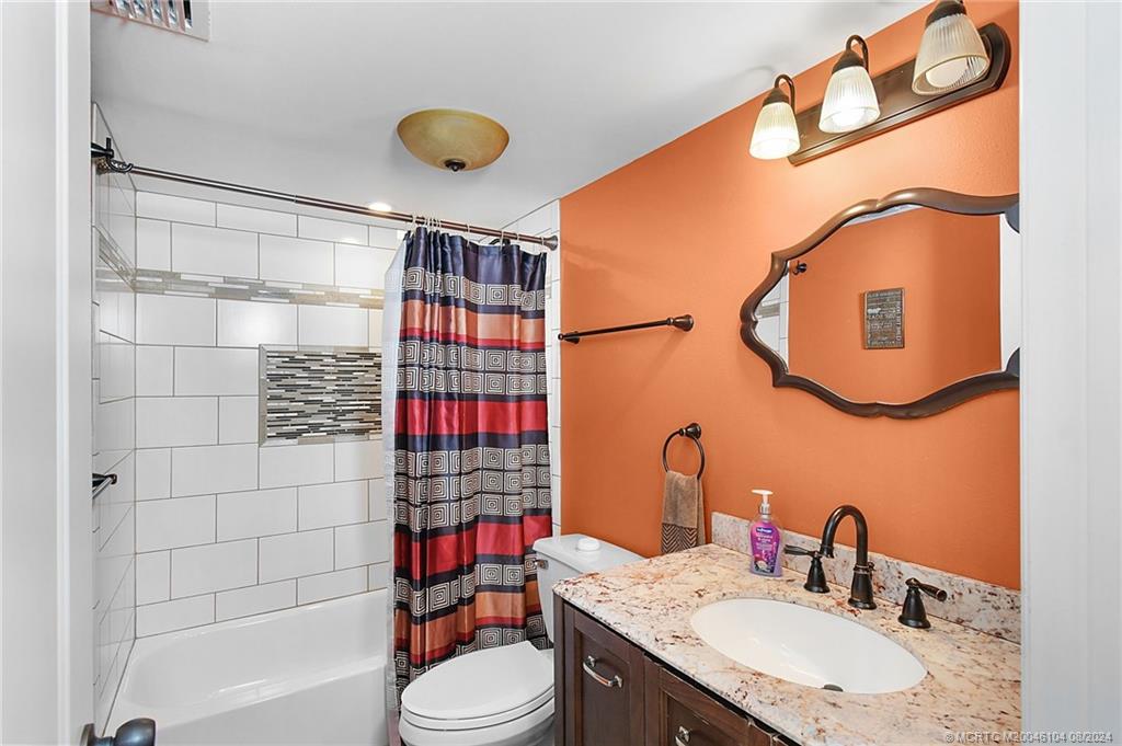311 Golfview Circle Stuart, FL 34996 - Photo 23 of 37 a bathroom with a sink vanity mirror and toilet