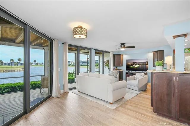 a living room with furniture a flat screen tv and a floor to ceiling window