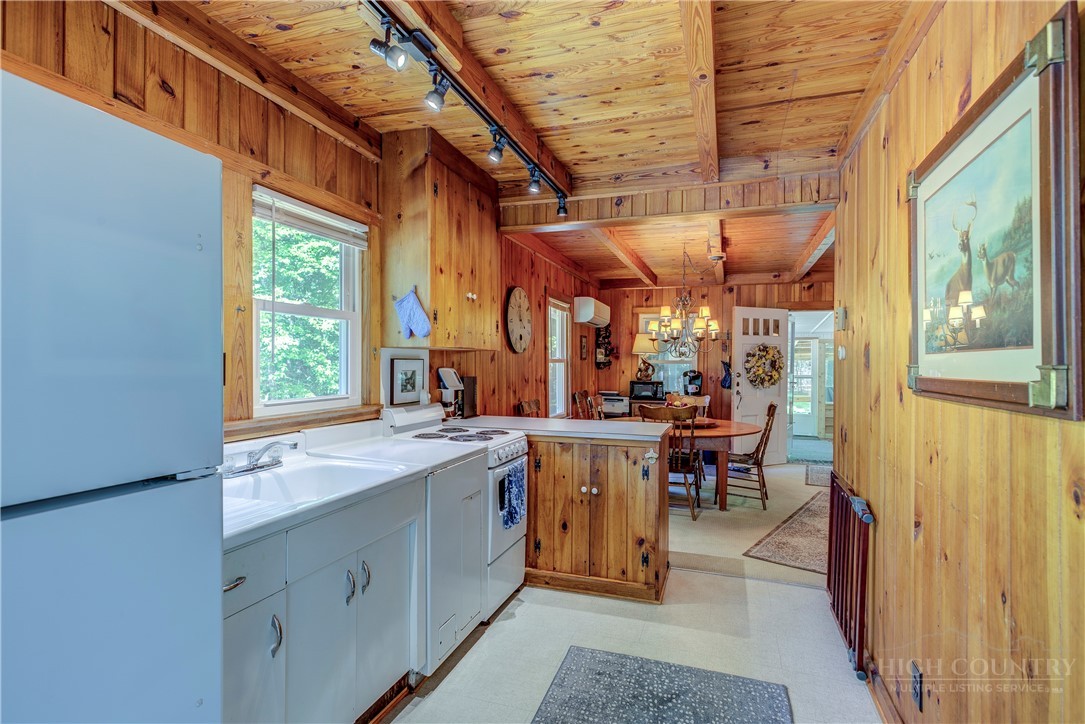 1010 Rash Road Glade Valley, NC 28627 - Photo 17 of 50 a view of a kitchen with a sink and dishwasher a barbeque oven with a dining table and chair