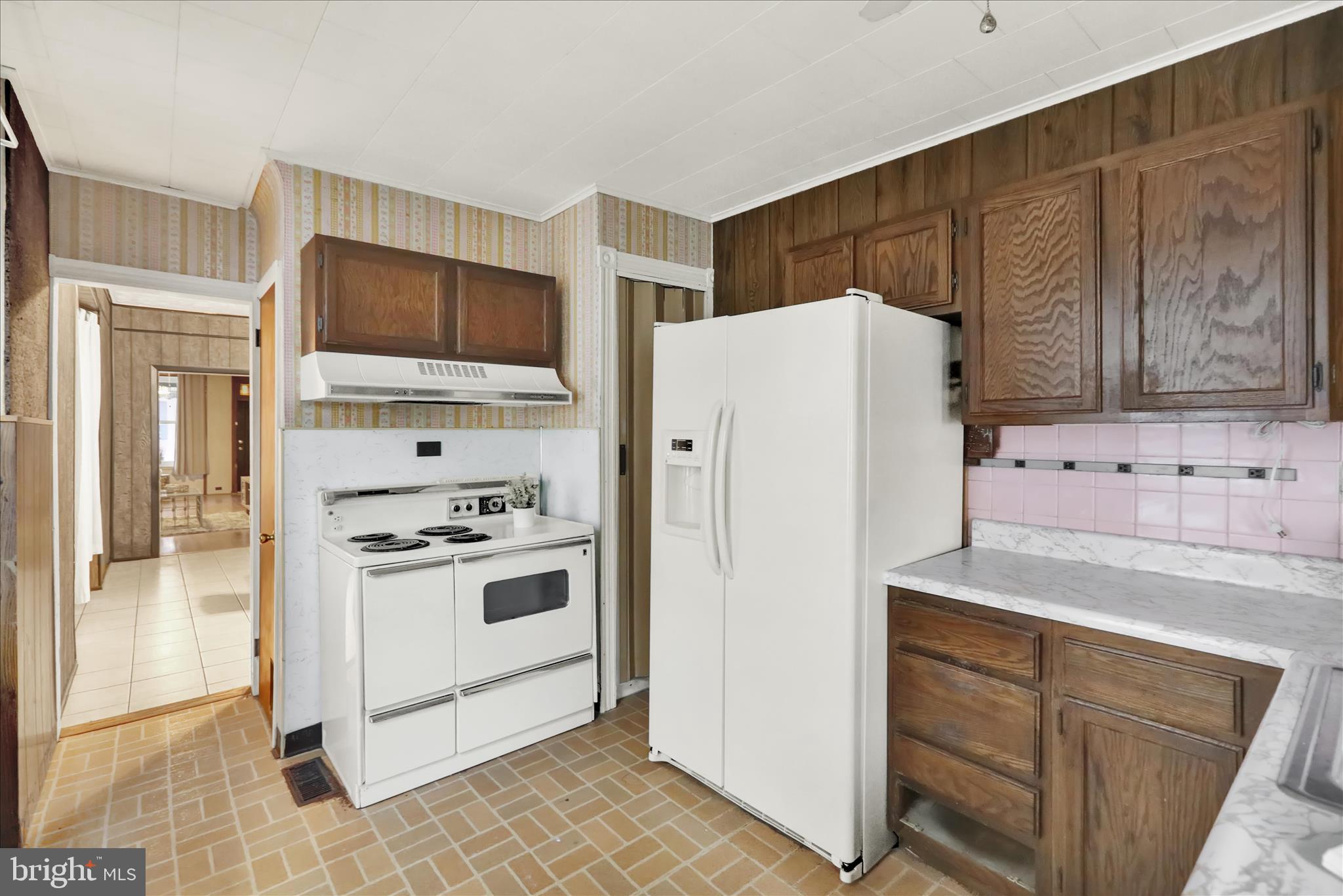 1217 Windsor Street Reading, PA 19604 - Photo 12 of 38 a white refrigerator freezer sitting inside of a kitchen with stainless steel appliances
