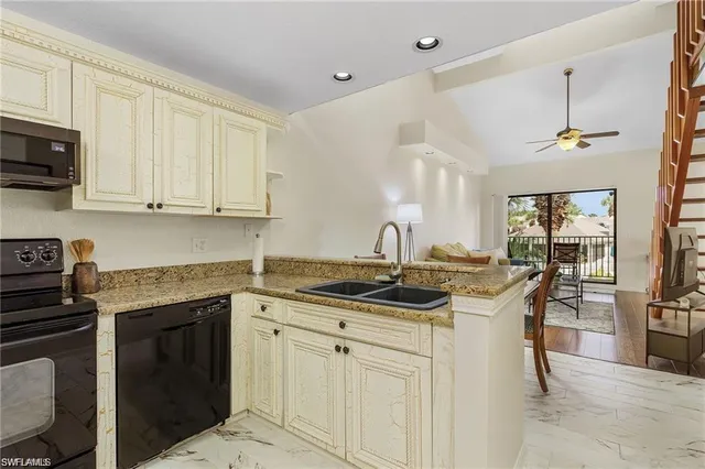 a kitchen with stainless steel appliances granite countertop a sink a stove and cabinets