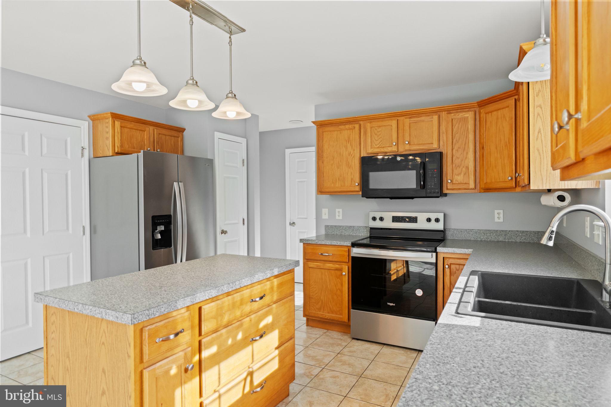 1014 Daisy Drive Temple, PA 19560 - Photo 22 of 83 a kitchen with stainless steel appliances granite countertop a sink a stove top oven a refrigerator cabinets and a window