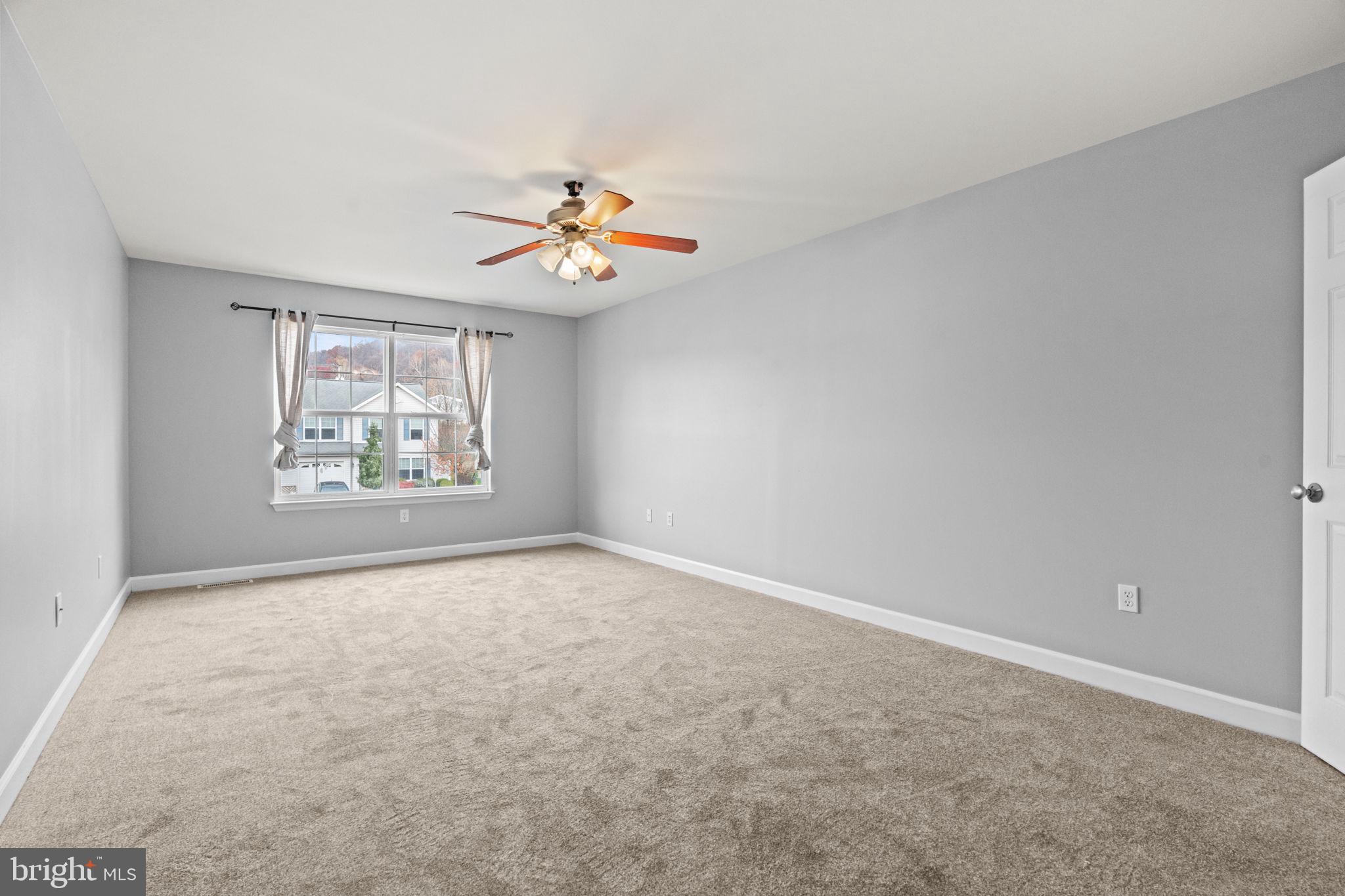 1014 Daisy Drive Temple, PA 19560 - Photo 55 of 83 an empty room with windows and chandelier fan