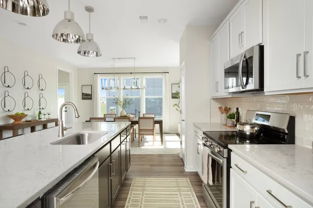 a kitchen with stainless steel appliances granite countertop a sink stove and cabinets