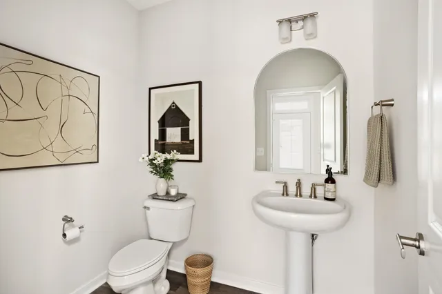 a bathroom with a toilet sink and mirror