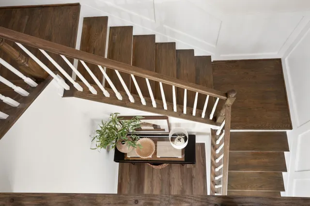 a view of staircase with railing and white walls