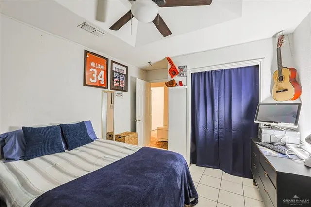 a bedroom with a bed and a flat tv screen on the dresser