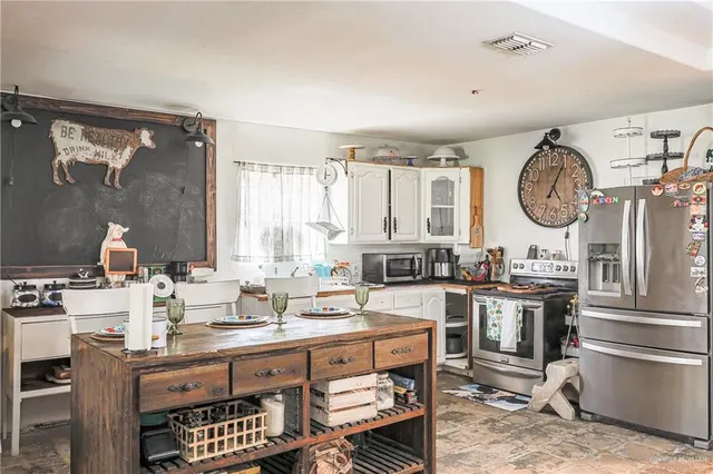 a living room with kitchen island furniture a chandelier and a wooden floor