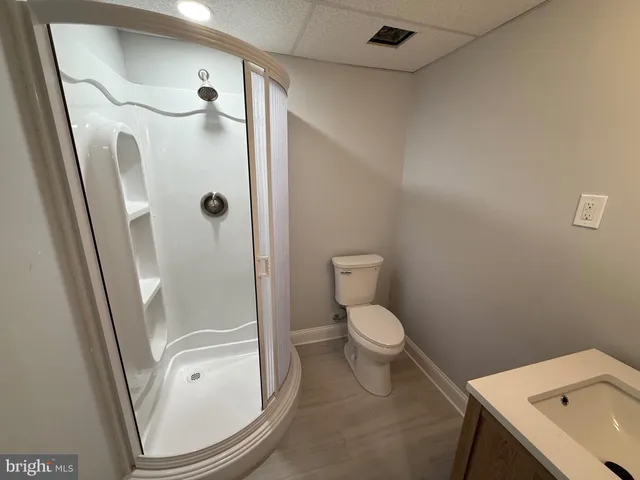a bathroom with a granite countertop toilet and a sink