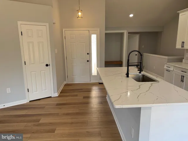 a kitchen with stainless steel appliances a refrigerator a sink and wooden floors