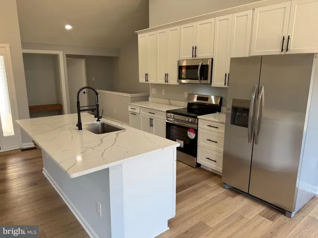 a kitchen with stainless steel appliances a microwave a sink a stove and a refrigerator