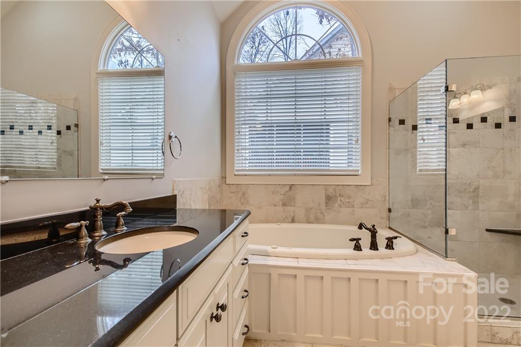 7653 Juniper Lane Denver, NC 28037 - Photo 13 of 28 a bathroom with a granite countertop sink mirror and tub