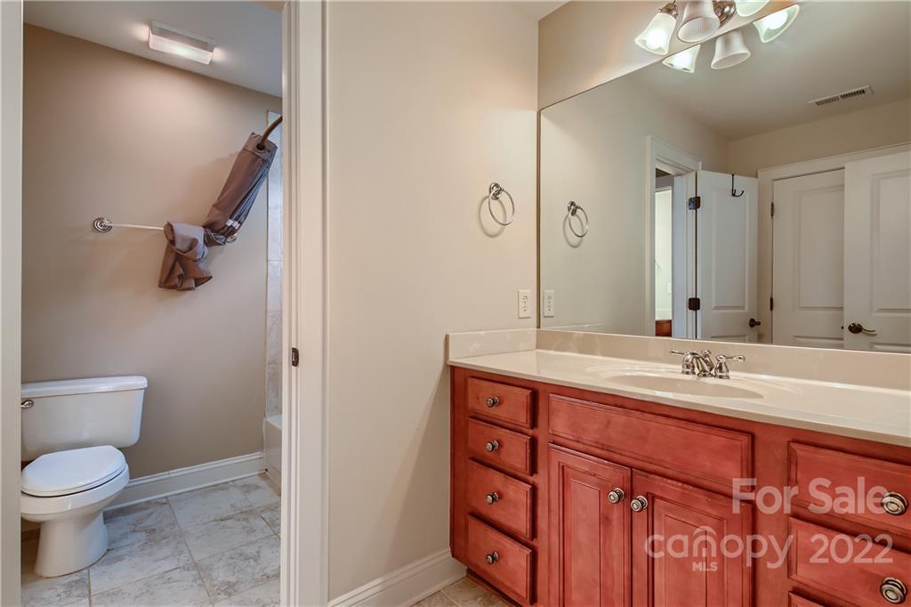 7653 Juniper Lane Denver, NC 28037 - Photo 19 of 28 a bathroom with a granite countertop sink a toilet and a mirror