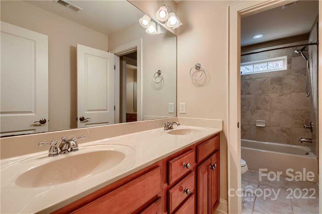 7653 Juniper Lane Denver, NC 28037 - Photo 20 of 28 a bathroom with a granite countertop sink a mirror and a shower