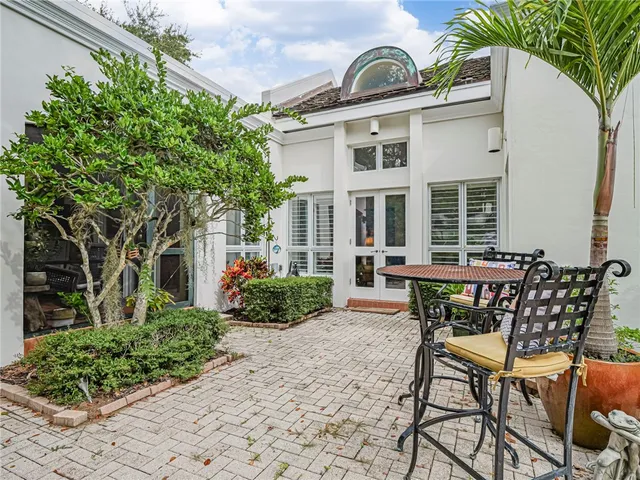 a view of a patio with table and chairs and potted plants