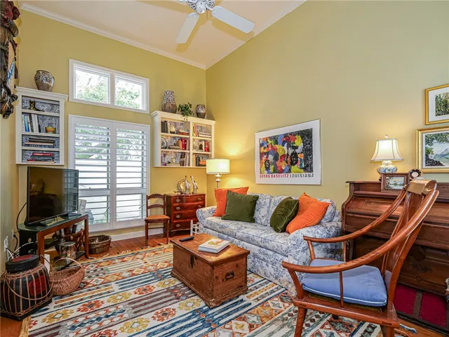 a living room with furniture a flat screen tv and a window