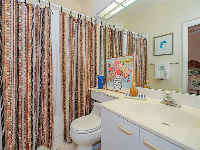 a bathroom with a sink toilet and shower curtain