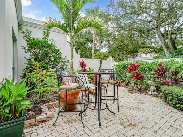 a view of a backyard with chair and potted plants