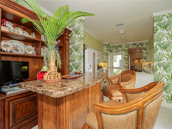a view of a kitchen with granite countertop a sink a stove and a chandelier