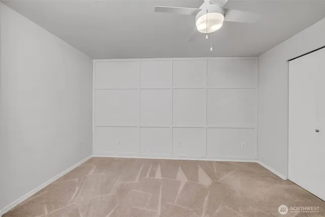 a view of an empty room with chandelier fan