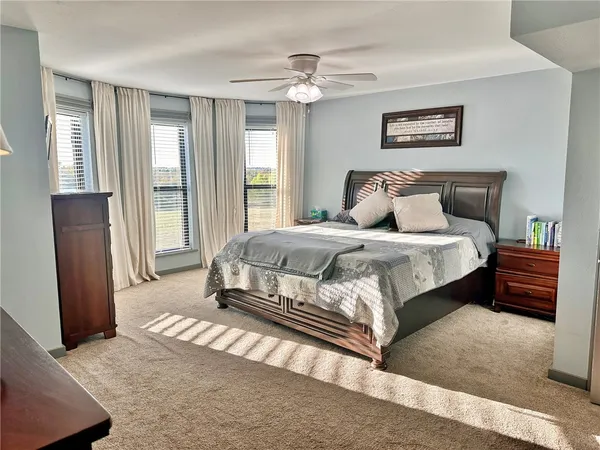 a bedroom with a large bed and a chandelier