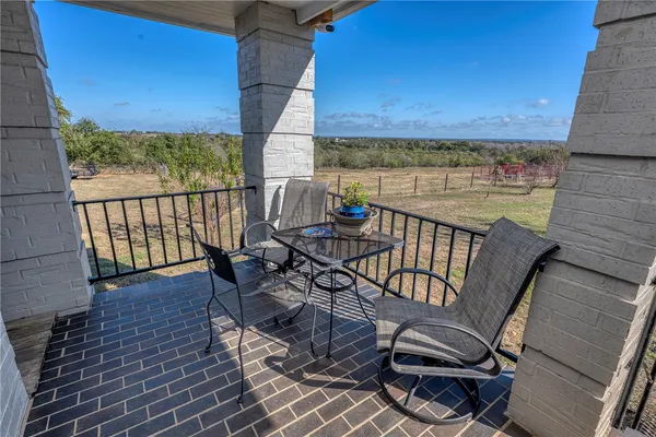 a view of a balcony with wooden floor and outdoor seating