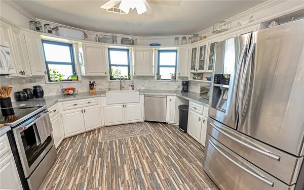 a kitchen with white cabinets and white appliances