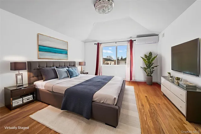 a spacious bedroom with a bed and a flat screen tv