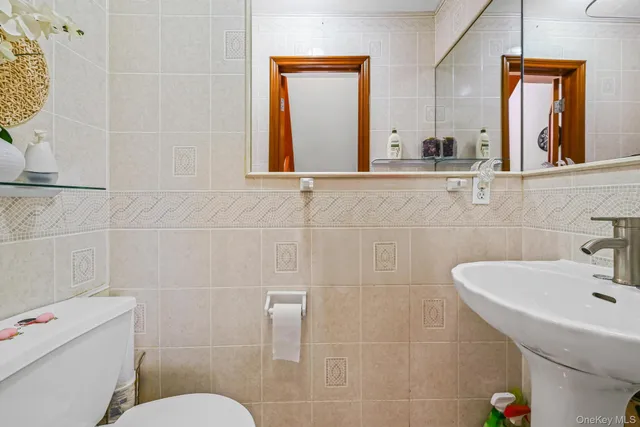 a bathroom with a sink a toilet and mirror